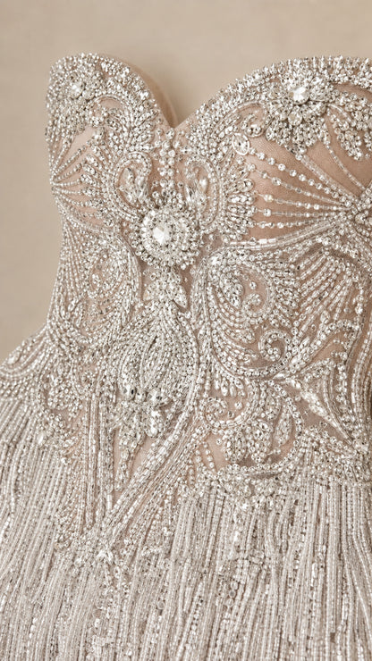 Close-up detail of ornate crystal beading and tassel fringe on bodice