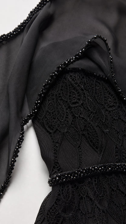 Close-up detail of textured leaf lace overlay and delicate beadwork trim