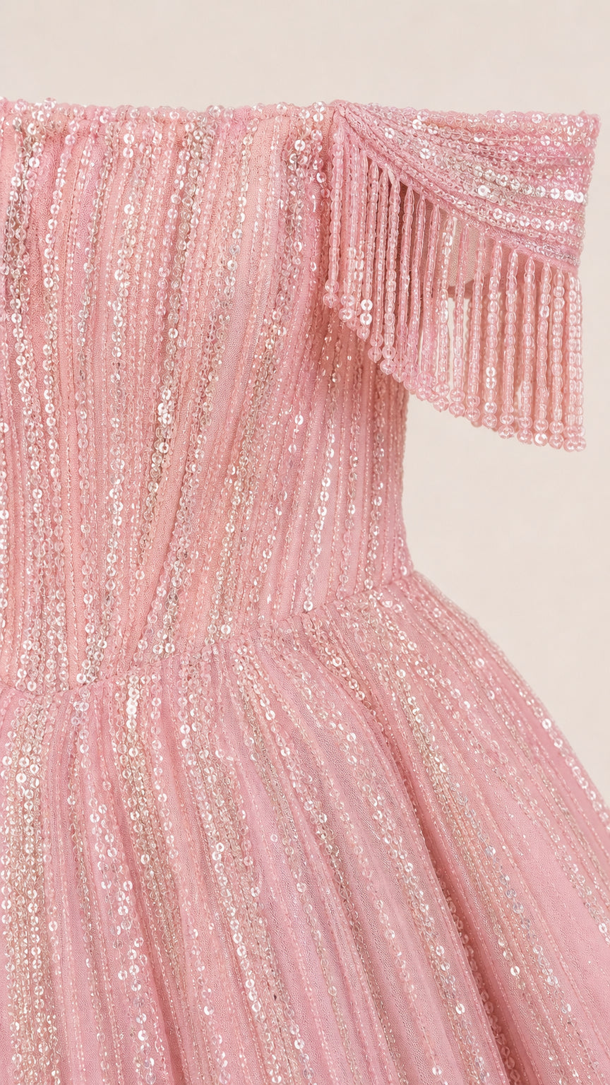 Close-up detail of pink sequin embellishment and beaded fringe shoulder strap