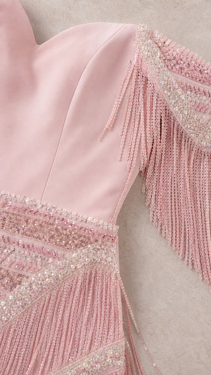 Close-up detail of dusty rose sweetheart neckline, beadwork, and tassel fringe sleeve