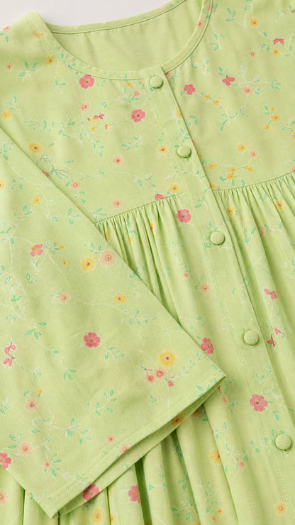 Close-up detail of light green floral fabric with covered buttons and neckline