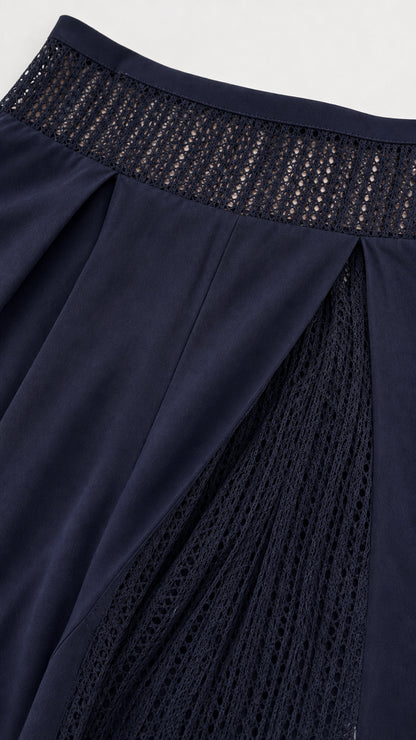 Close-up detail of navy blue crochet waistband and pleated side pants insert