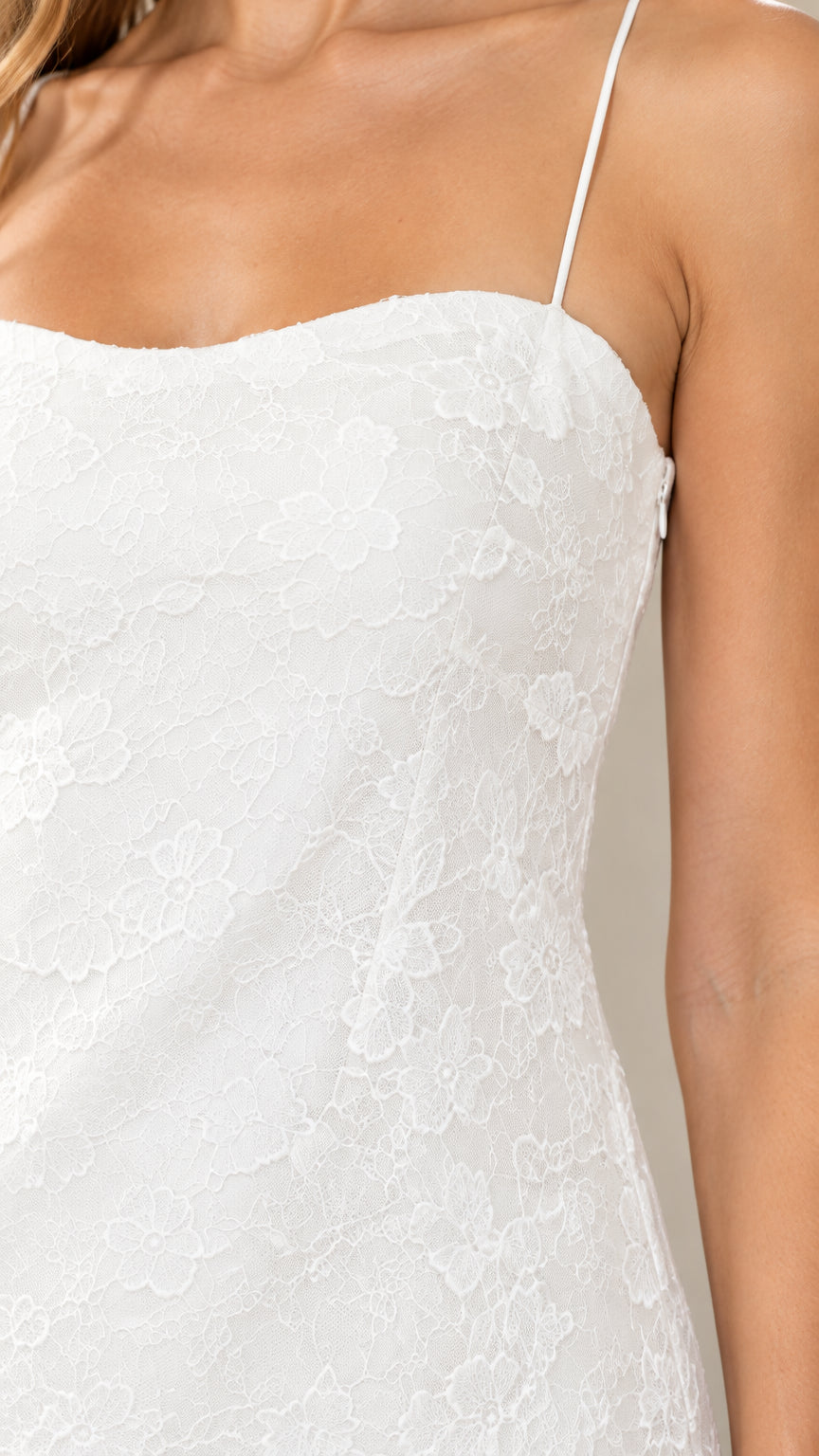 Close-up detail of white floral lace texture and spaghetti strap bodice