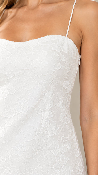 Close-up detail of white floral lace texture and spaghetti strap bodice