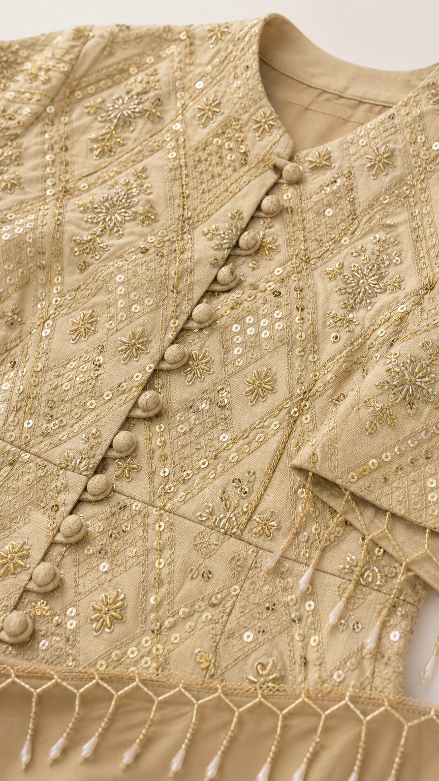 Close-up detail of geometric embroidery, sequin embellishments, and beaded tassel trim