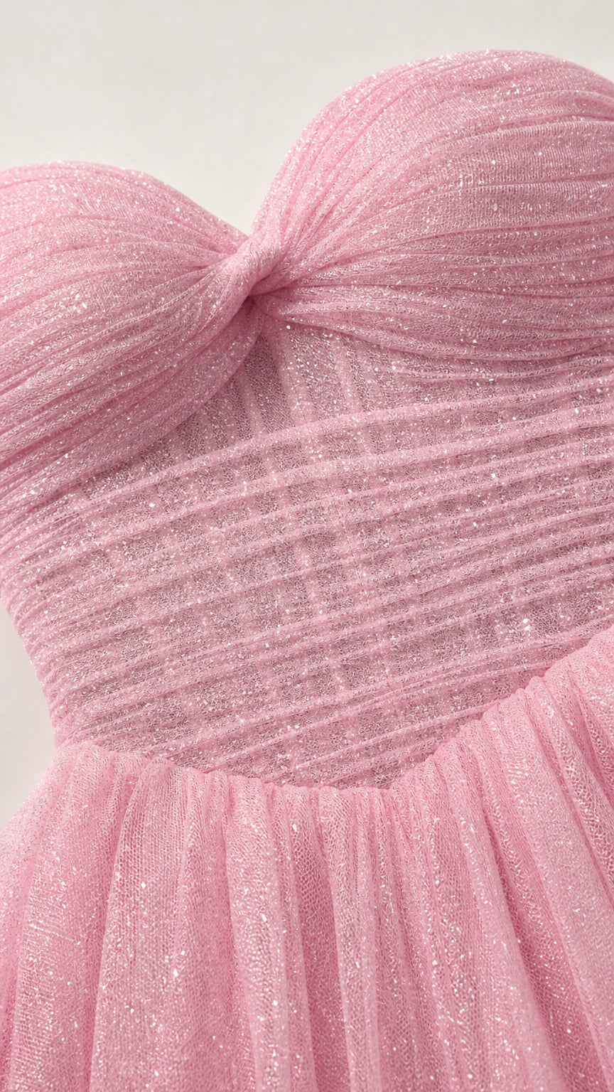 Close-up detail of pink ruched sweetheart bodice with glitter tulle fabric