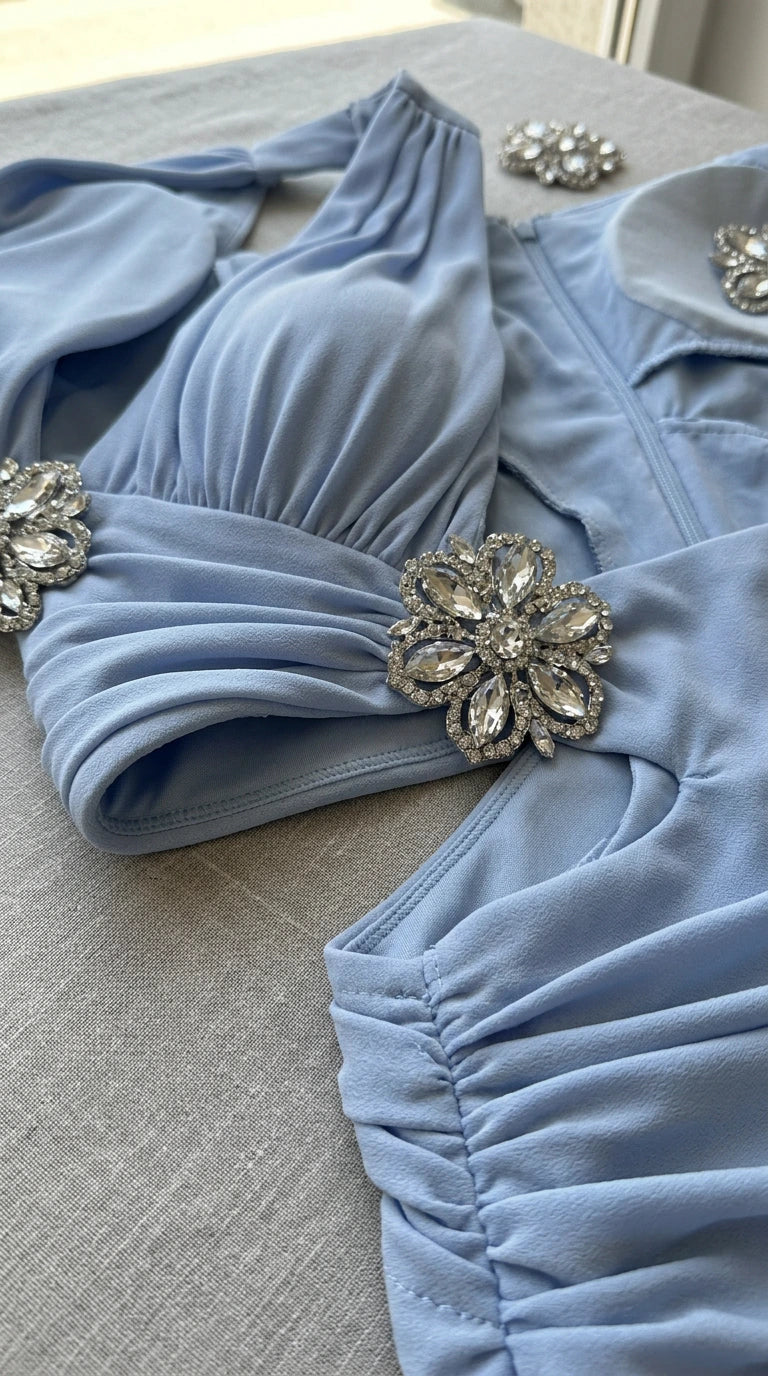 Close-up detail of crystal floral brooch and ruched halter neckline on Light Blue gown