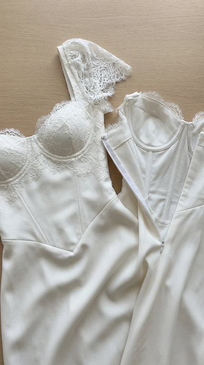 Close-up flat lay of white corset dress showing boned bodice and lace detail