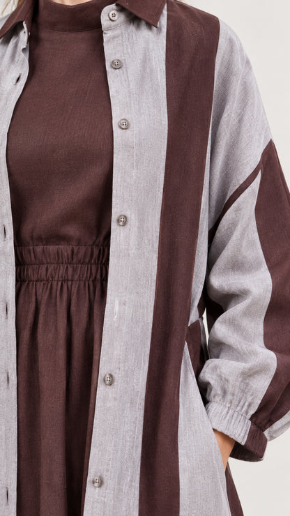 Close-up detail of fabric texture, button placket, high neckline, and elastic waist