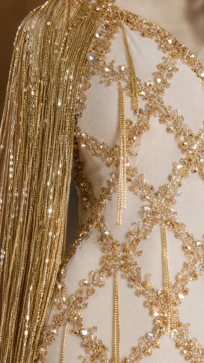 Close-up detail of intricate gold beadwork, sequins, and hanging beaded fringe