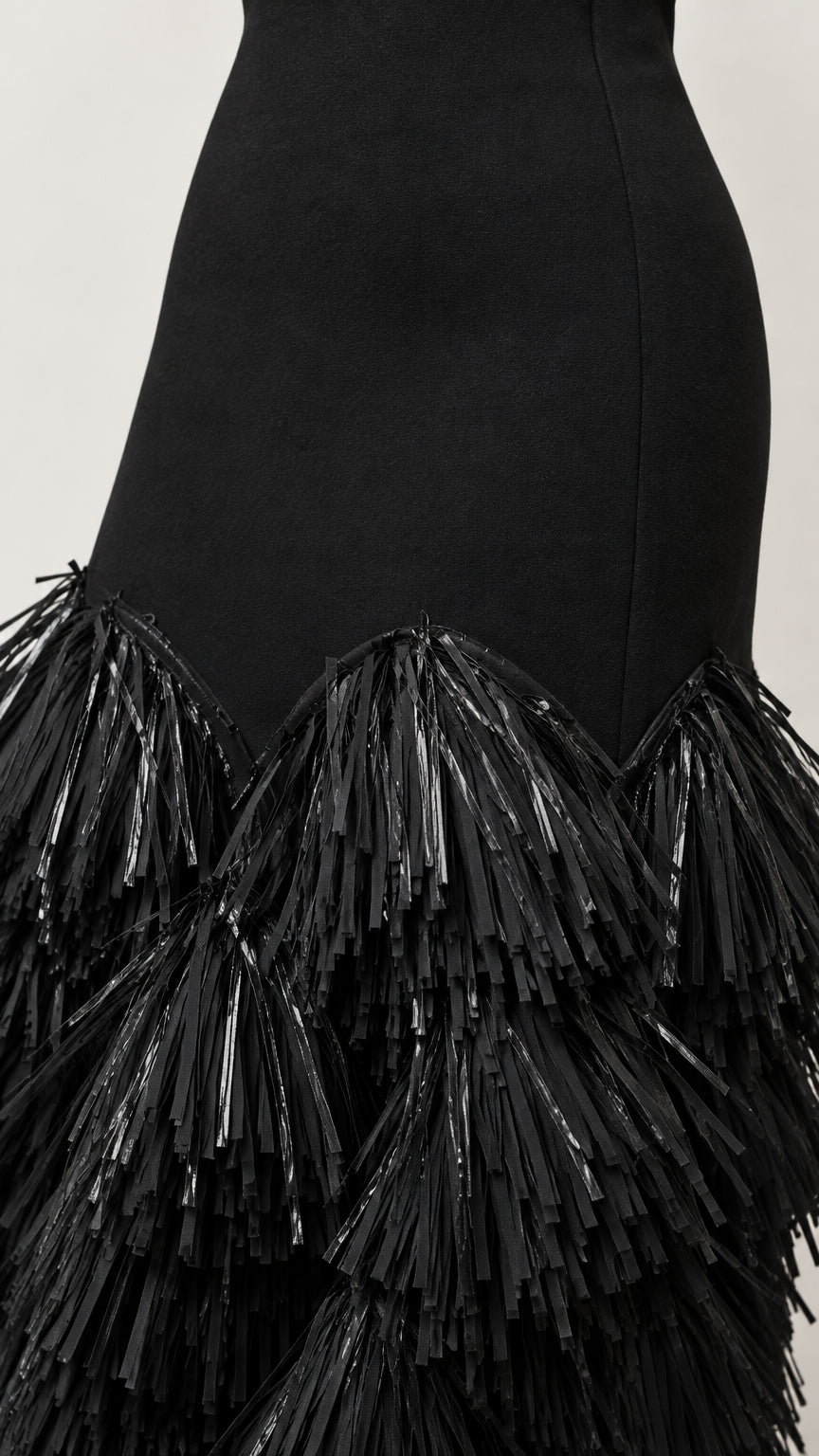 Close-up detail of textured fringe layers on black evening dress