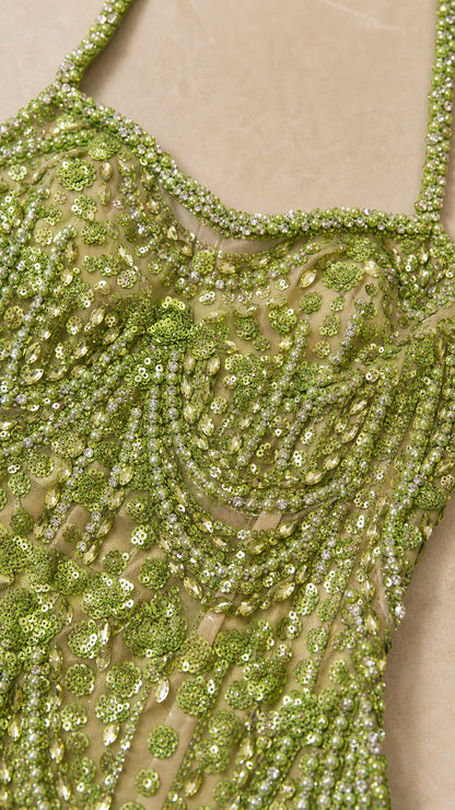 Close-up detail of green beaded scalloped embroidery and sequins