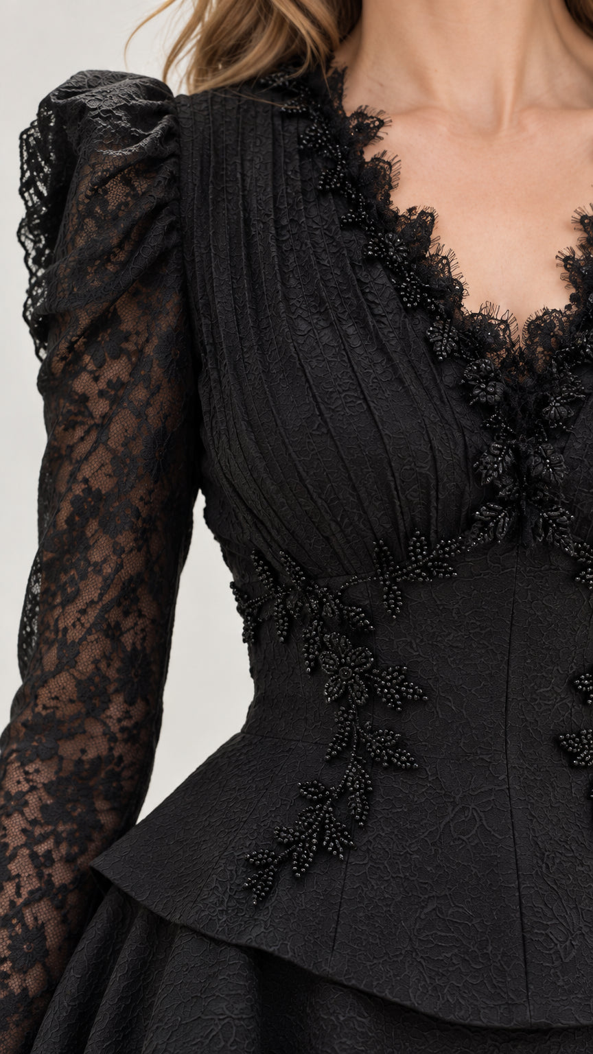 Close-up detail of beaded V-neckline, sheer lace sleeves, and peplum bodice embroidery