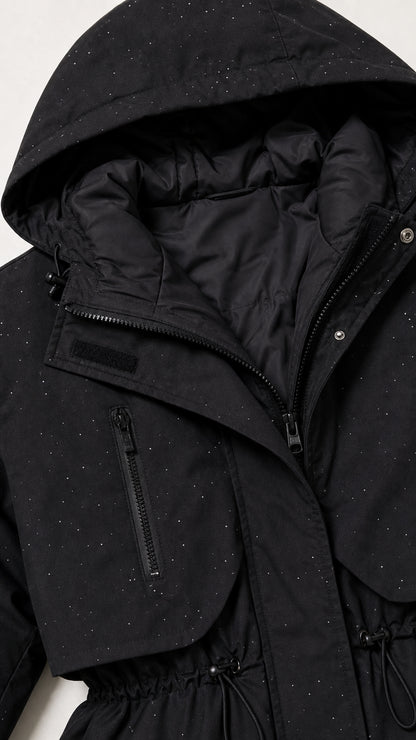 Close-up detail of black parka showing hood lining, zipper placket, and subtle speckle print