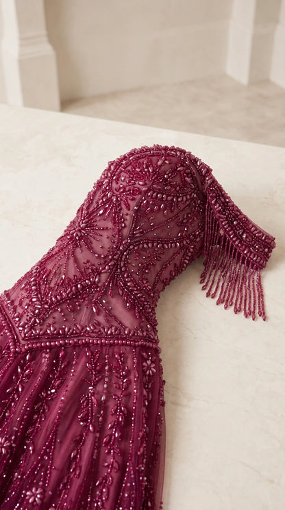 Close-up detail of burgundy beaded embroidery and delicate fringe sleeve trim