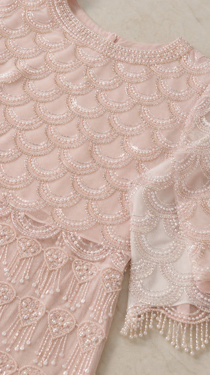 Close up detail of intricate pearl beading and scalloped trim on evening gown