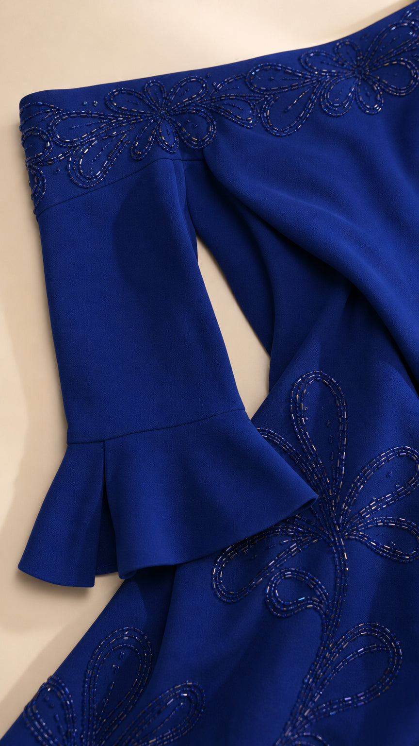 Close-up detail of tonal bead embroidery on the neckline and fluted cuff in Royal Blue