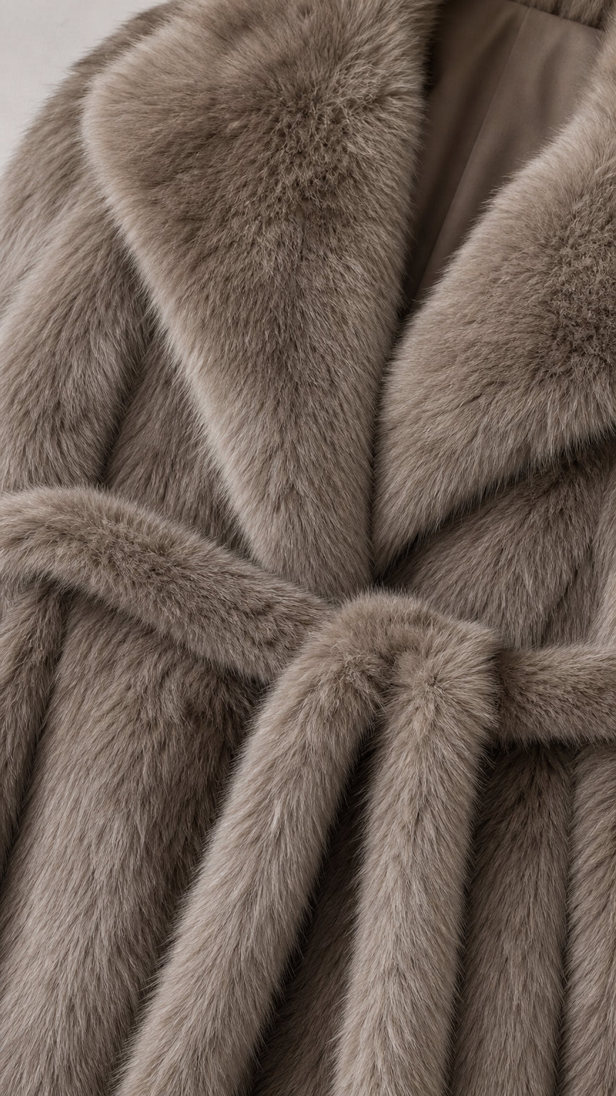 Close-up detail of plush taupe faux fur fabric, collar lapel, and belt texture