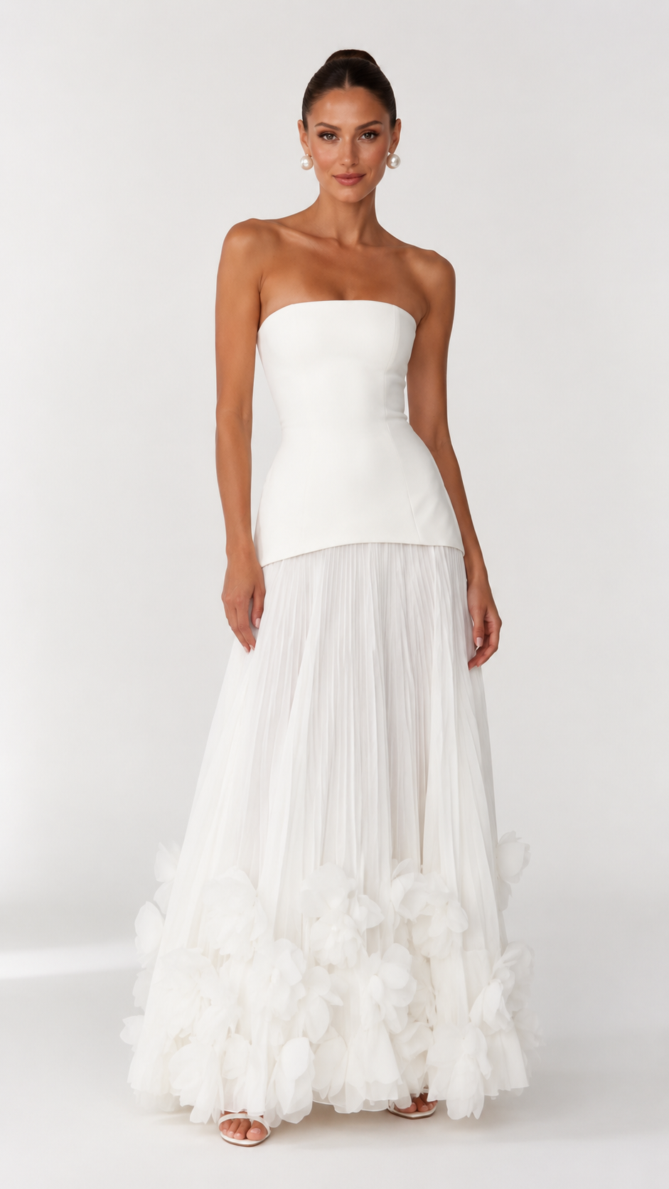 Front view of ivory strapless formal dress with textured floral hem detail