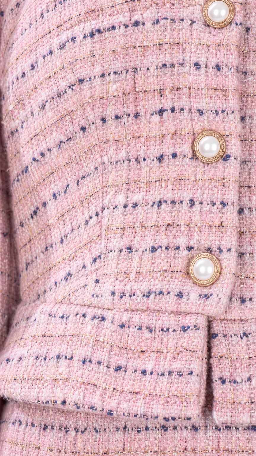 Close-up of pink tweed woven texture and gold-rimmed pearl buttons