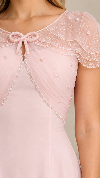 Close-up detail of blush pink beaded mesh capelet and front bow neckline