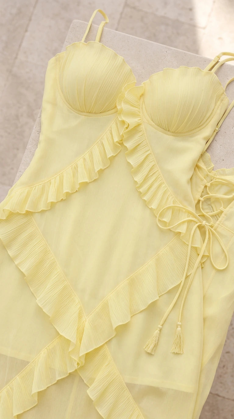 Close-up flat lay of pastel yellow bustier bodice and tiered ruffle details