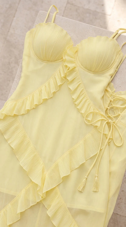 Close-up flat lay of pastel yellow bustier bodice and tiered ruffle details
