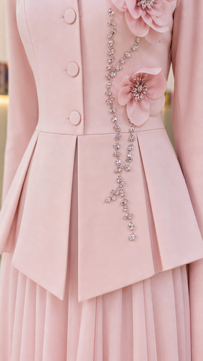 Close-up detail of blush pink jacket with 3D floral applique, beaded vine, and peplum pleats