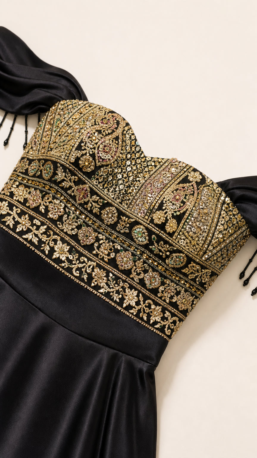 Close-up detail of ornate gold embroidery and beading on the off-the-shoulder dress bodice