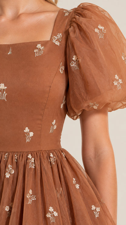 Close-up detail of sheer puff sleeve, square neckline, and floral embroidery on bodice