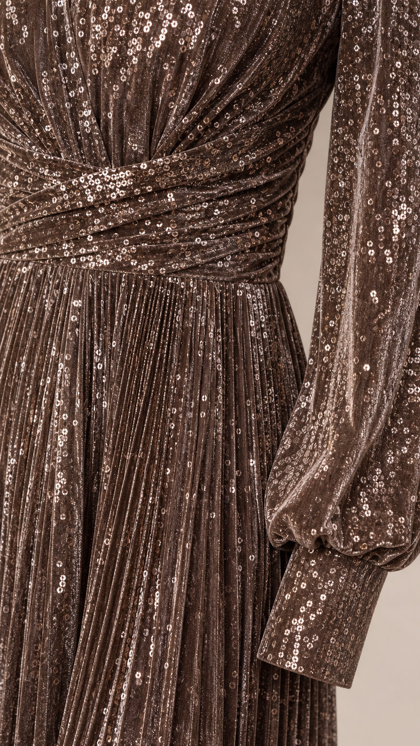 Close-up detail of sequin fabric, crossover waistband, and pleated skirt