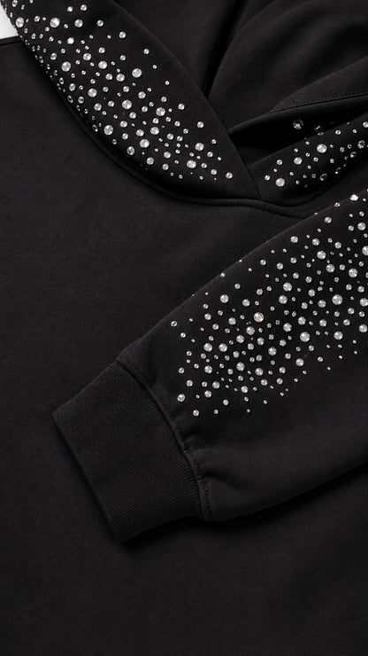 Close-up detail of rhinestone crystals on the hood and ribbed sleeve cuff