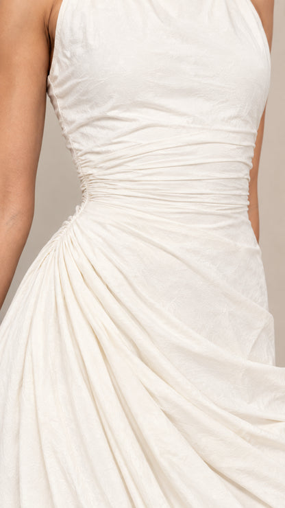 Close-up detail of ruching and fabric texture on ivory draped dress