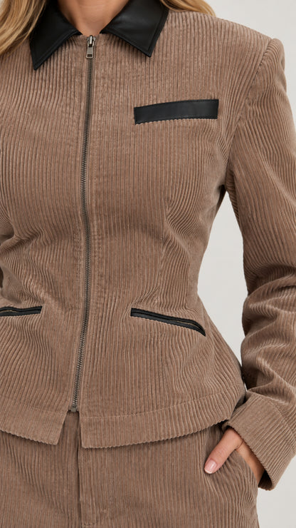 Close-up detail of taupe ribbed corduroy texture, zip closure, and contrast black collar