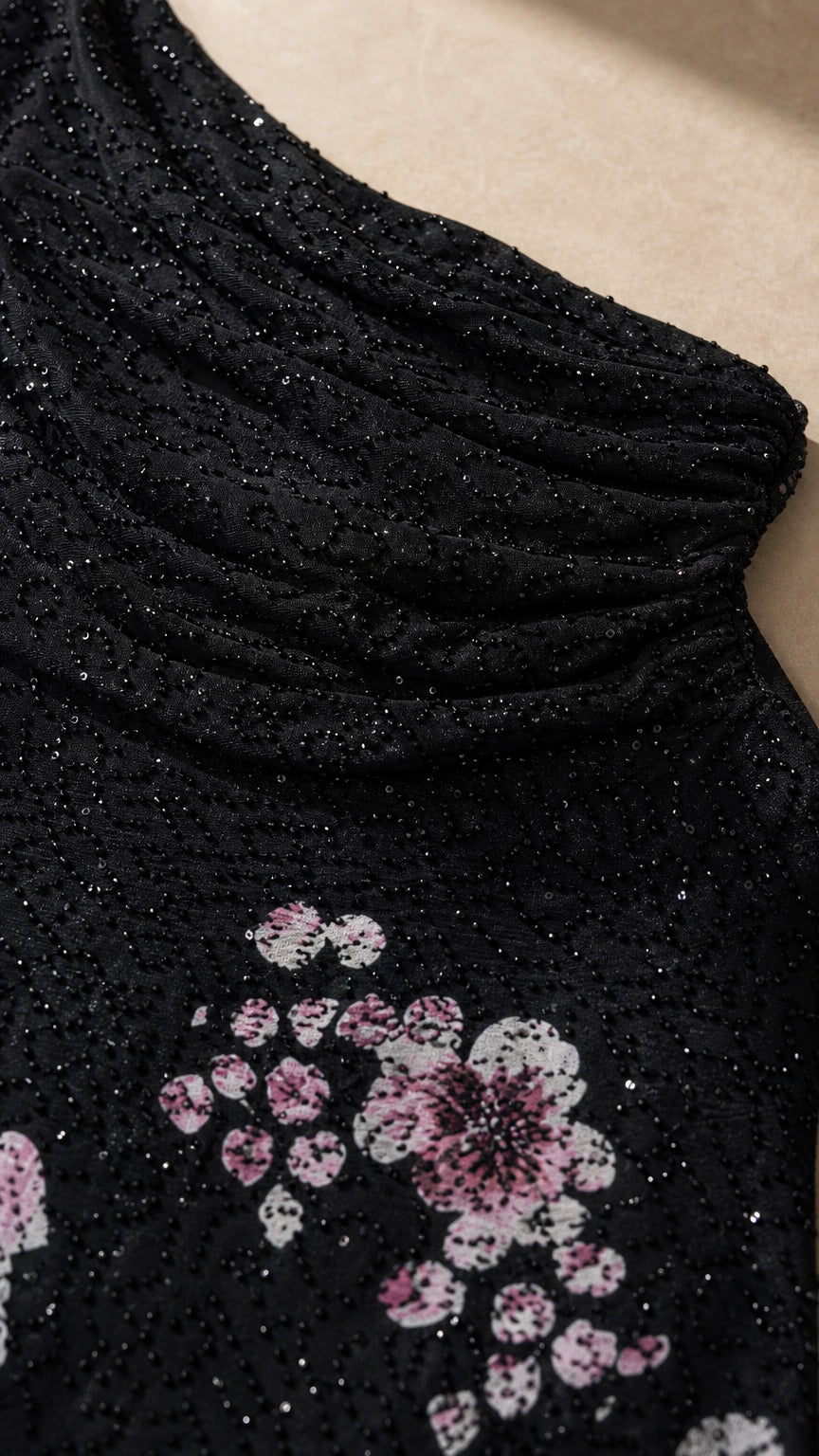 Close-up detail of textured shimmer fabric and floral print on black formal dress