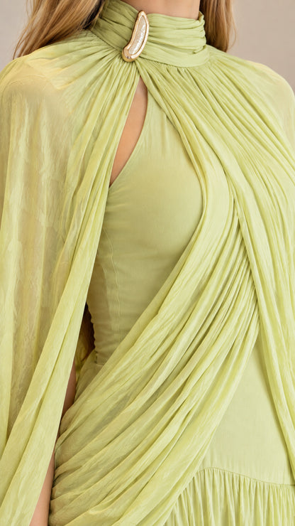 Close-up detail of high neckline, teardrop keyhole, brooch accent, and draped bodice