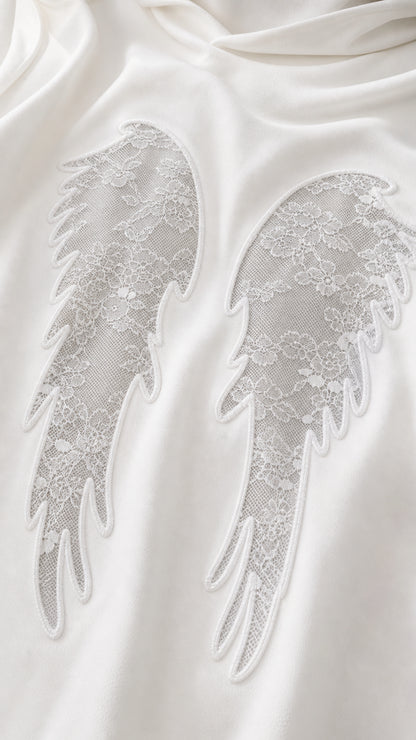 Close-up detail of lace angel wings applique on soft knit fabric