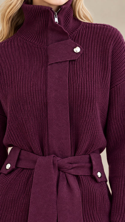 Close-up detail of high neck zipper, flap hardware, belt loops, and ribbed knit texture in plum