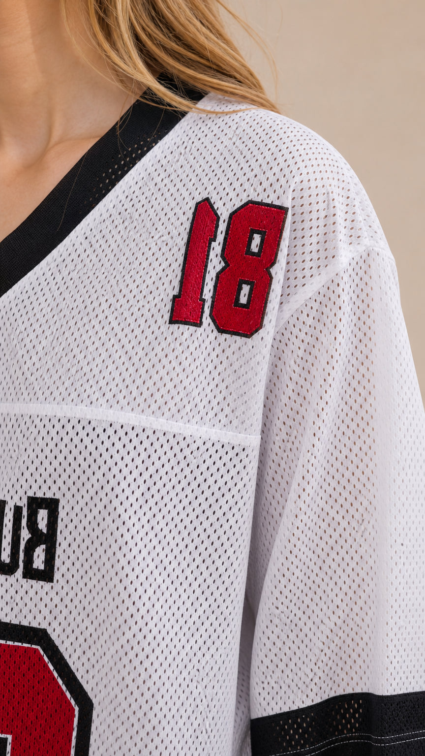 Close-up detail of white breathable mesh fabric, contrast neckline, and red graphic print