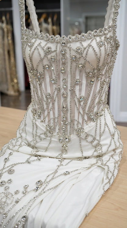 Close-up of white bodice detailing showing crystal beading and corset boning structure