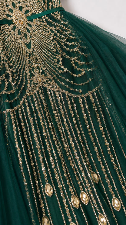 Close-up detail of intricate gold beading and sequin tassels on emerald green tulle dress