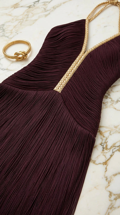 Close-up flat lay of burgundy fringe bodice with gold braided halter trim