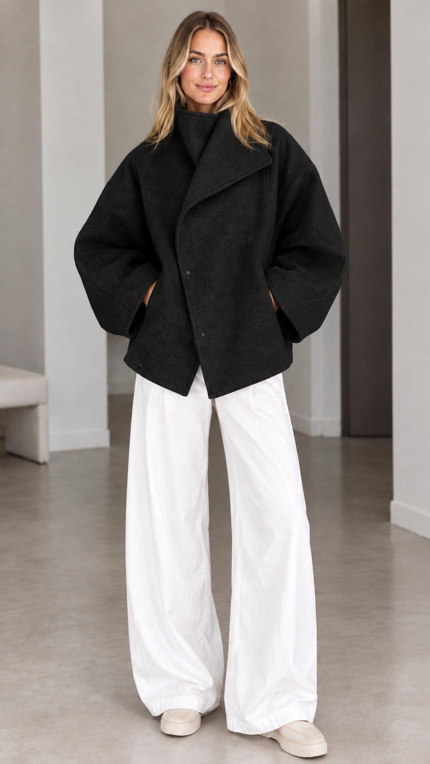 Model wearing classic black asymmetrical high neck short jacket