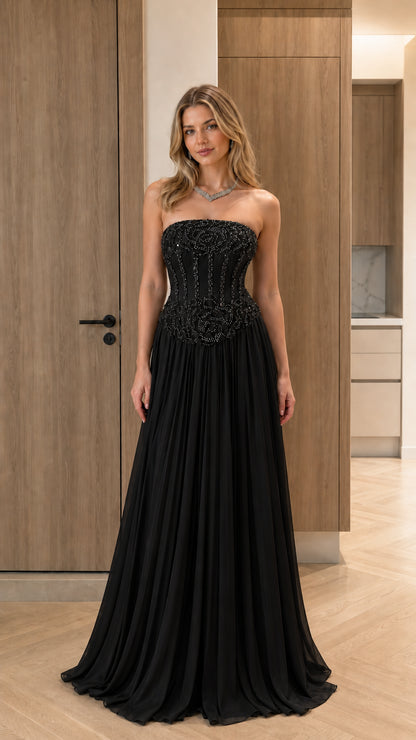 Model wearing classic black strapless beaded corset pleated evening gown