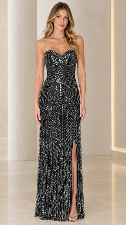 Model wearing black strapless beaded fringe evening gown with slit