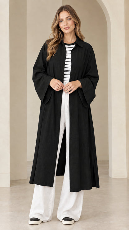Model wearing black longline button-down duster over a striped tee and white pants