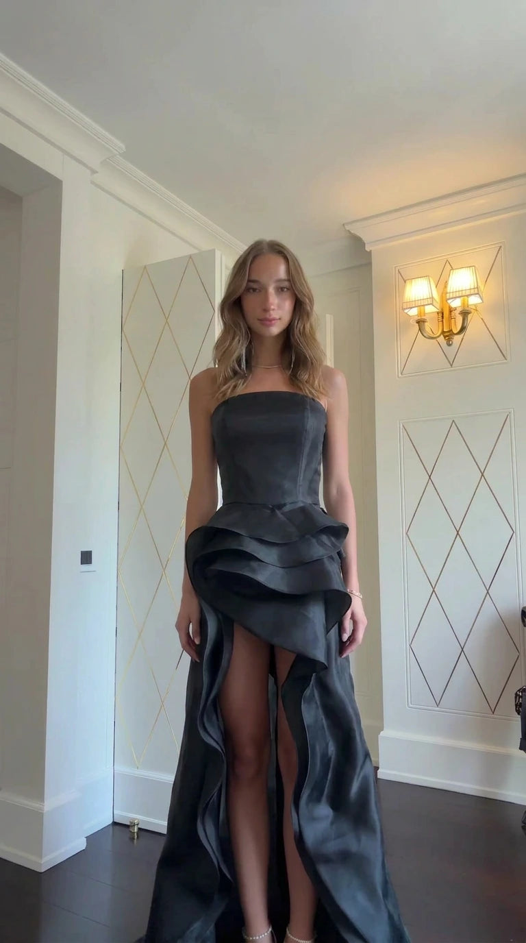 Model wearing Black strapless tiered ruffle high-slit formal gown