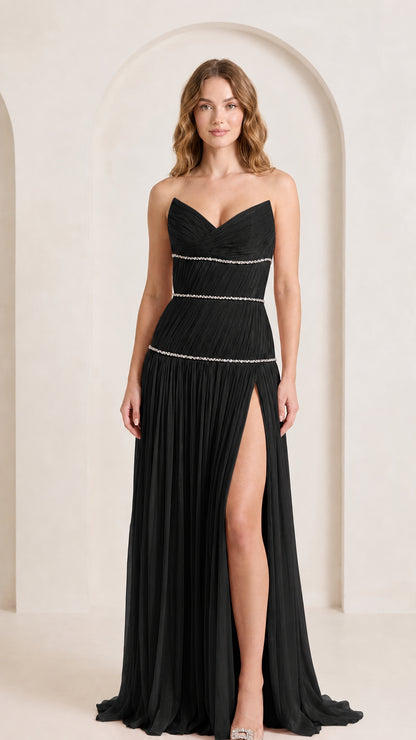 Front view of woman wearing black strapless pleated evening gown with rhinestone details