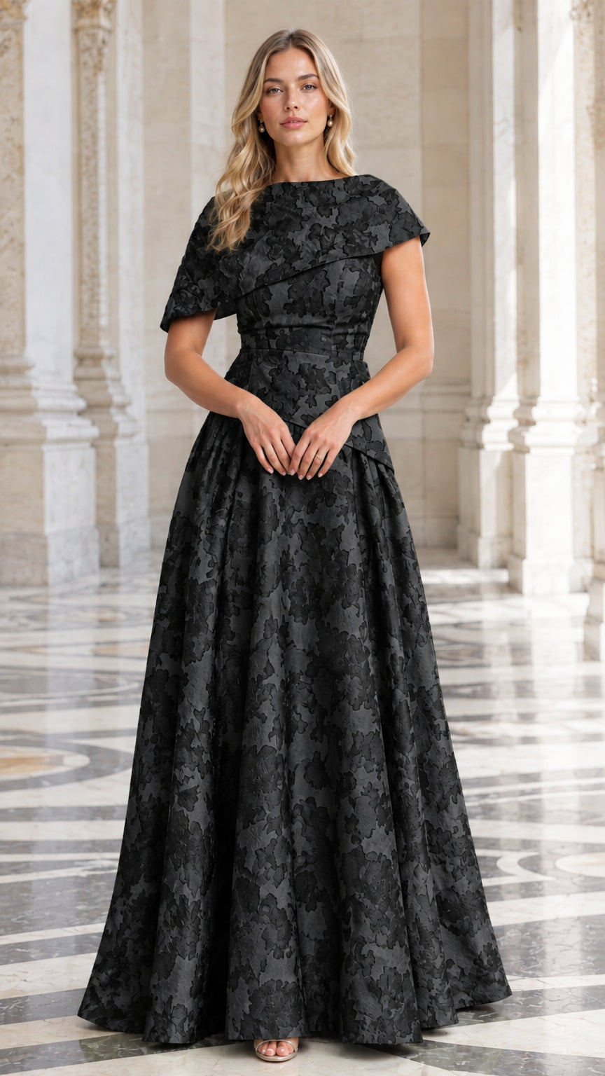 Model wearing Black floral jacquard A-line evening gown with capelet detail