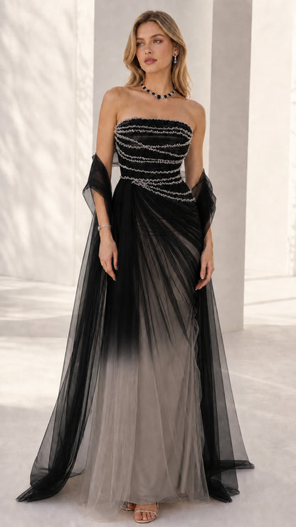 Front view of the strapless beaded evening gown in black to grey ombre tulle